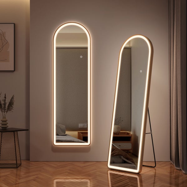 Zwei bogenförmige Ganzkörperspiegel mit integrierter LED-Beleuchtung, einer an der Wand montiert, einer mit Standfuß, in einem modernen Schlafzimmer.