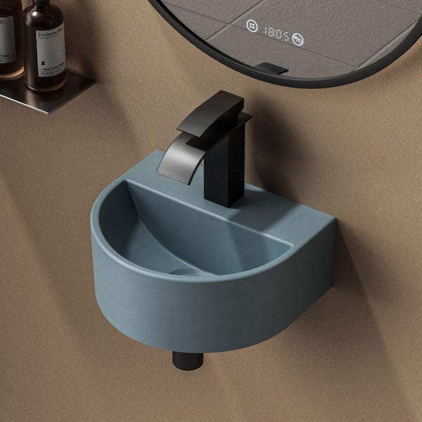 Blaues Aufsatzwaschbecken mit schwarzem Wasserhahn und Spiegel