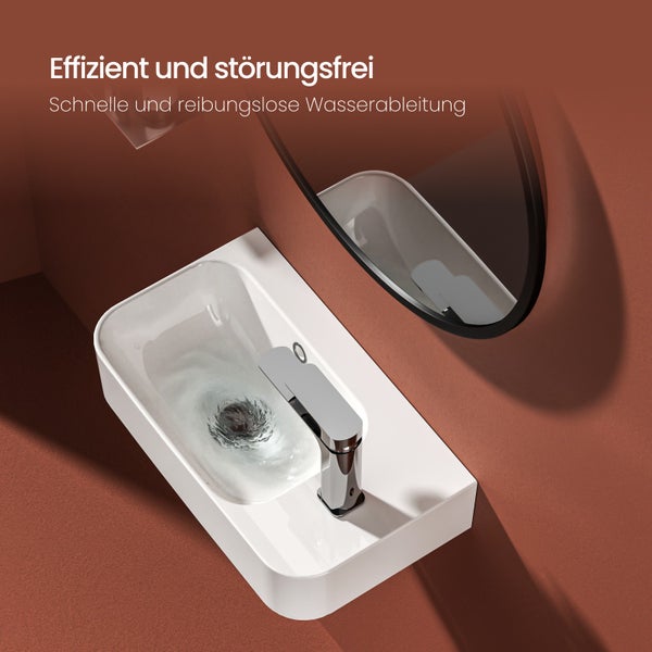 Waschtisch mit Armatur und Spiegel im Badezimmer