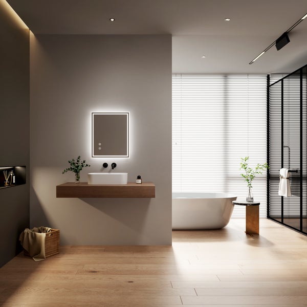 Modernes Badezimmer mit Waschtischkonsole aus Holz, Aufsatzwaschbecken, LED Spiegel und freistehender Badewanne vor einem Fenster mit Jalousien.