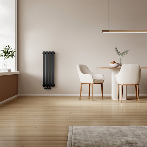 Moderner vertikaler Designheizkörper in einem hellen Esszimmer mit Holzboden und zwei Stühlen am Tisch.