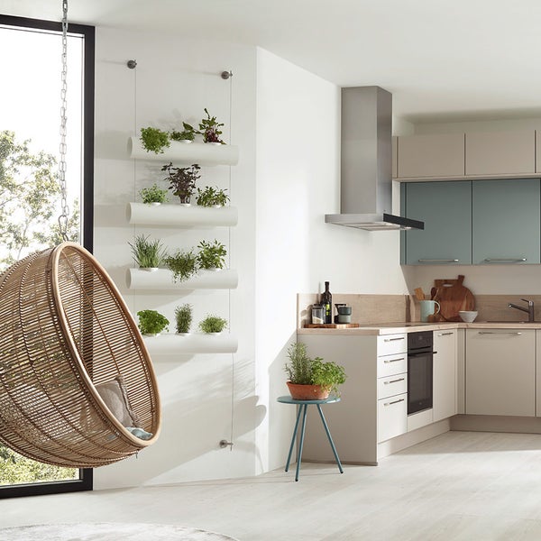 Moderne Küche mit Kräutergarten an der Wand und hängendem Rattansessel