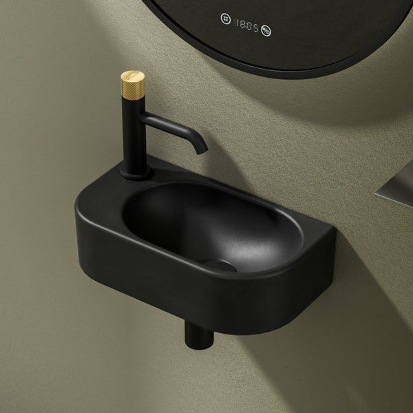Schwarzes Aufsatzwaschbecken mit Armatur vor einer Wand