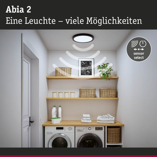 Abia 2 Deckenleuchte mit Sensor in einem hellen Raum mit Regalen und Waschmaschinen