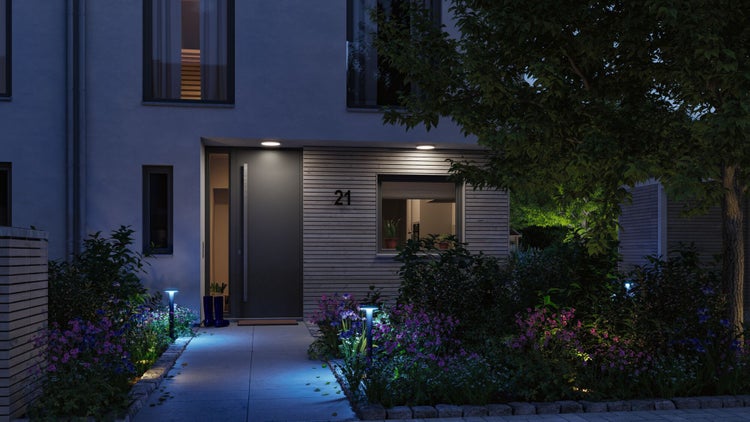 Fassade eines Hauses mit Hausnummer, Gartenbeleuchtung und Bepflanzung