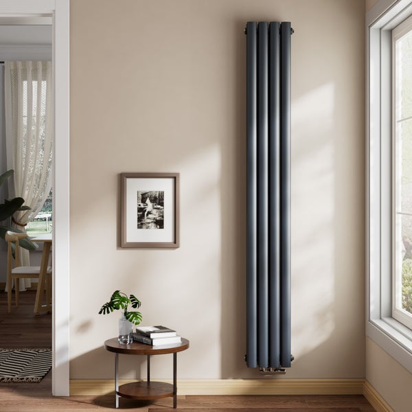 Vertikaler Röhrenheizkörper in einem hellen Wohnzimmer, an der Wand neben einem Fenster montiert. Minimalistisches Design mit dunklen Röhren.