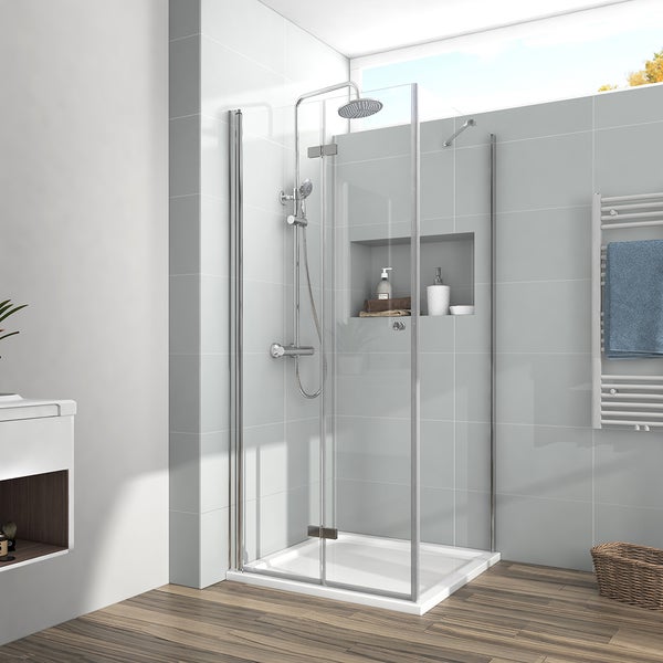 Modernes Badezimmer mit Glas-Duschkabine, Duschsystem mit Regenduschkopf und Handbrause, hellen Fliesenwänden und einem Handtuchheizkörper.