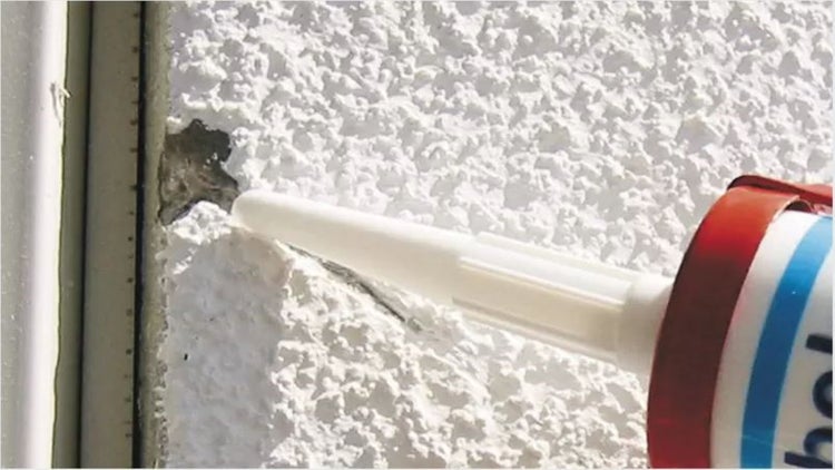 Eine Fassade wird mit Dichtmasse abgedichtet.