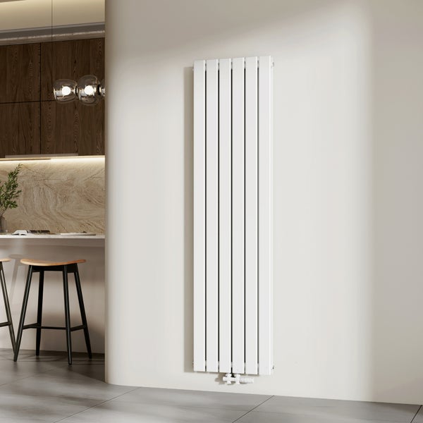 Vertikaler Designheizkörper mit flachen Paneelen in einem hellen, modernen Wohnraum neben einer Küche mit Barhockern und Holzschränken.