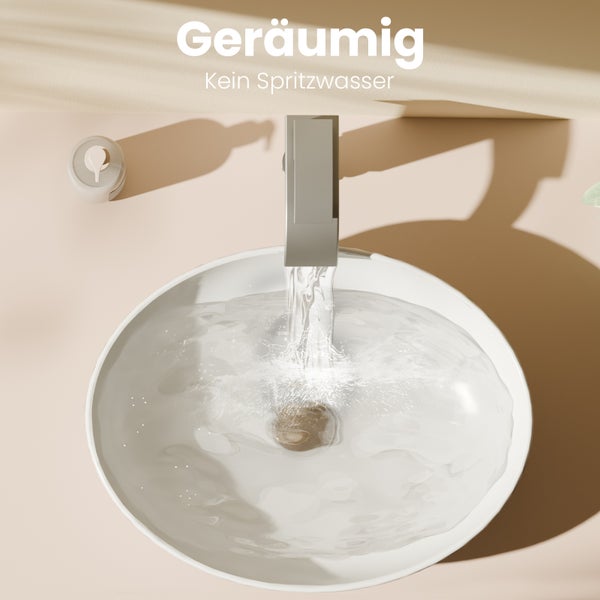 Draufsicht auf ein geräumiges weißes Aufsatzwaschbecken mit einer modernen grauen Armatur, aus der Wasser ohne Spritzer fließt.