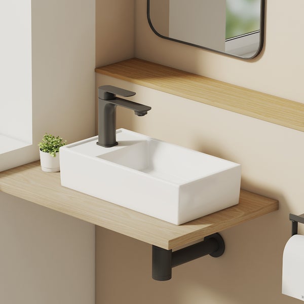 Modernes Badezimmer mit rechteckigem Aufsatzwaschbecken aus Keramik, Armatur, Holzkonsole und passendem Siphon.