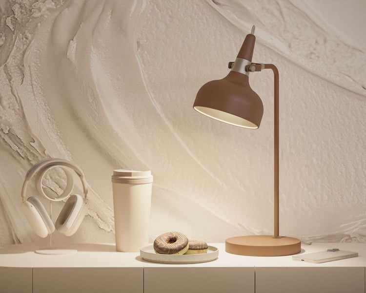 Dekorative Szene mit Tischlampe, Kopfhörern, Getränkebecher, Donuts und Mobiltelefon auf einer Kommode.