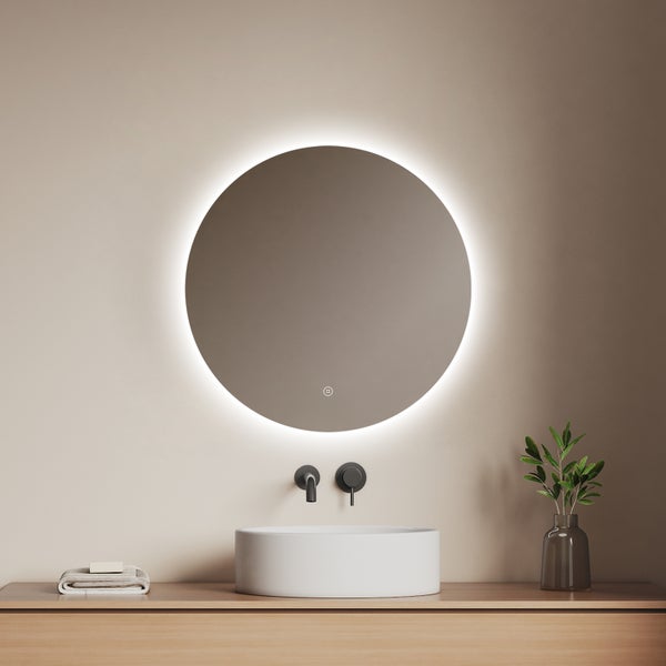Runder Badezimmerspiegel mit LED-Hintergrundbeleuchtung über einem weißen Aufsatzwaschbecken und einer schwarzen Wandarmatur.