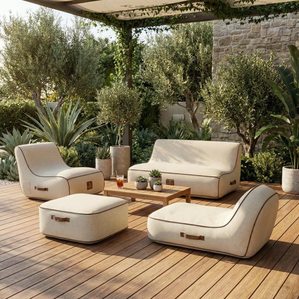 Helles, modernes Lounge-Set aus beigem Stoff mit Sofa, Sesseln und Hocker auf einer Holzterrasse umgeben von Olivenbäumen und Agaven.