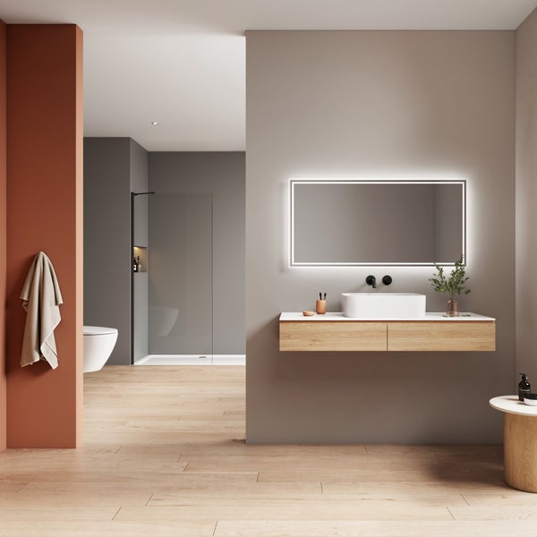 Modernes Badezimmer mit Waschtisch aus Holz, Aufsatzwaschbecken, beleuchtetem Wandspiegel und begehbarer Dusche im Hintergrund.