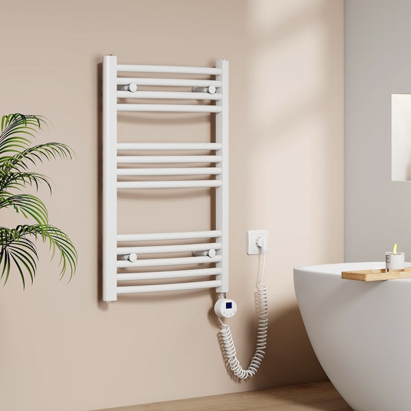 Elektrischer Handtuchheizkörper an einer Wand neben einer Badewanne mit digitalem Thermostat und Spiralkabel in einem modernen Badezimmer.