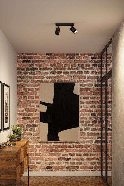 Raumansicht mit gemauerter Wand, beleuchtet durch einen Deckenstrahler