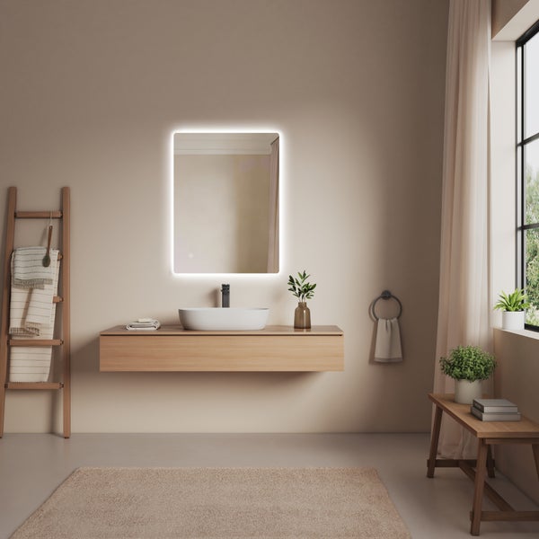 Modernes Badezimmer mit beleuchtetem LED-Spiegel, hängendem Holz-Waschtisch, Aufsatzwaschbecken, Handtuchleiter und hellem Interieur.