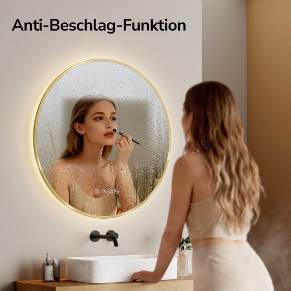 Runder Badezimmerspiegel mit LED Beleuchtung und Anti Beschlag Funktion. Ein Bereich ist klar, der Rest beschlagen. Goldfarbener Rahmen.
