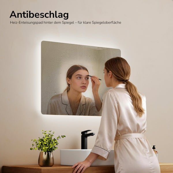 Frau vor einem beschlagfreien Spiegel mit LED-Beleuchtung im Badezimmer