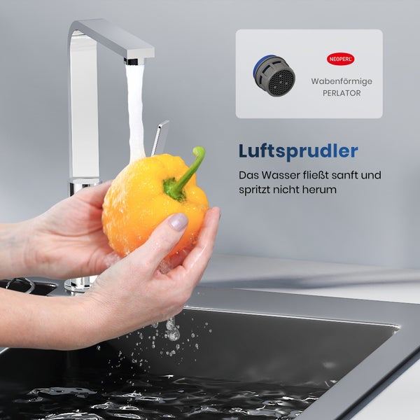 Frau wäscht Paprika unter einer Küchenarmatur mit Luftsprudler
