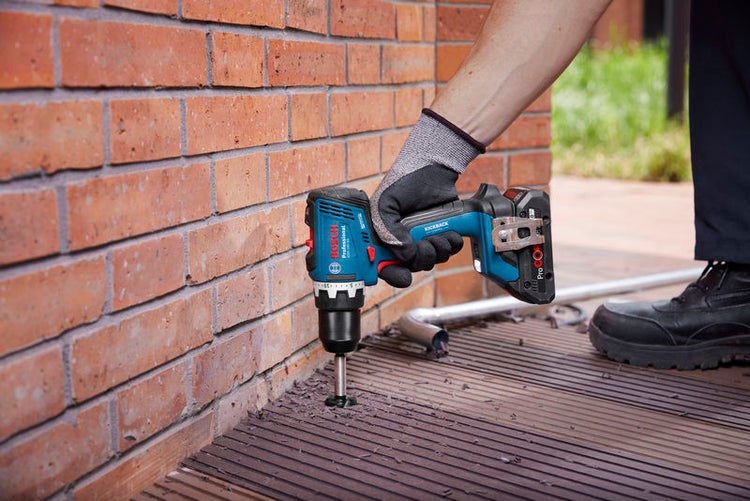 Bohren mit einem Akku-Bohrhammer in eine Steinwand