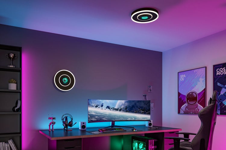 Modernes Gaming-Zimmer mit ringförmigen LED-Wand- und Deckenleuchten sowie farbiger RGB-Beleuchtung am Schreibtisch.
