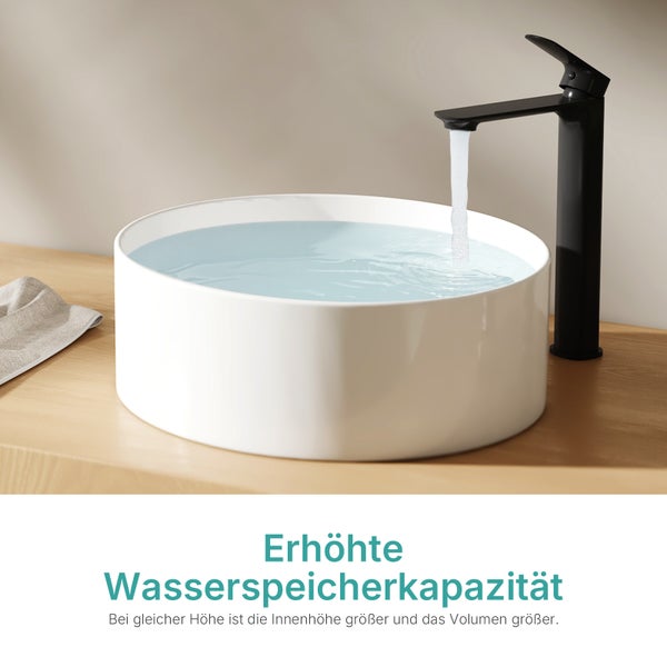 Rundes weißes Aufsatzwaschbecken mit erhöhter Kapazität auf einer Holzplatte mit schwarzer Armatur und fließendem Wasser.