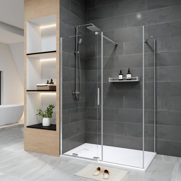 Moderne Duschkabine mit Schiebetür aus Glas, flacher Duschwanne, Regenduschkopf und dunklen Wandfliesen in einem hellen Badezimmer.