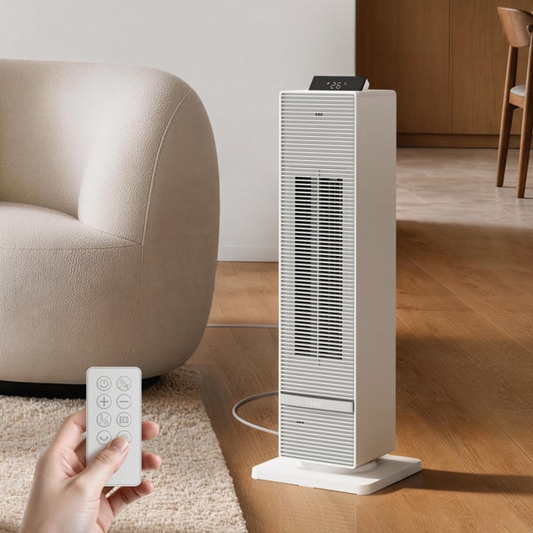 Elektrischer Turmheizlüfter mit Fernbedienung in einem Wohnzimmer mit Sitzmöbeln auf einem Holzboden.