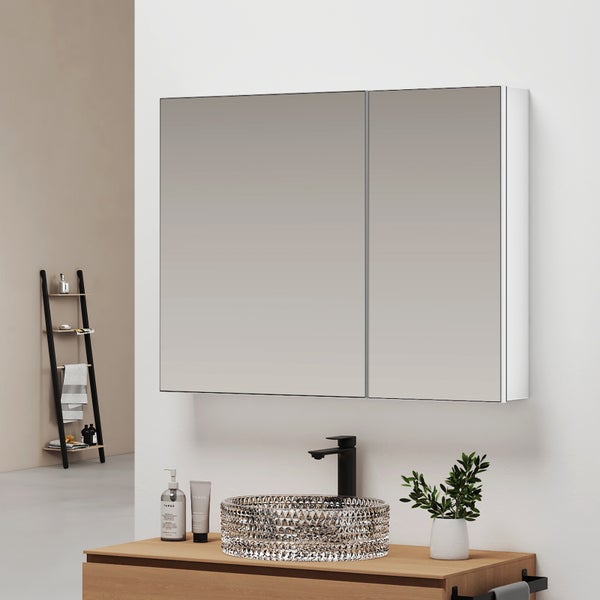 Moderner Spiegelschrank im Badezimmer mit zwei Türen, montiert über einem Waschtisch aus Holz mit Glaswaschbecken und schwarzer Armatur.