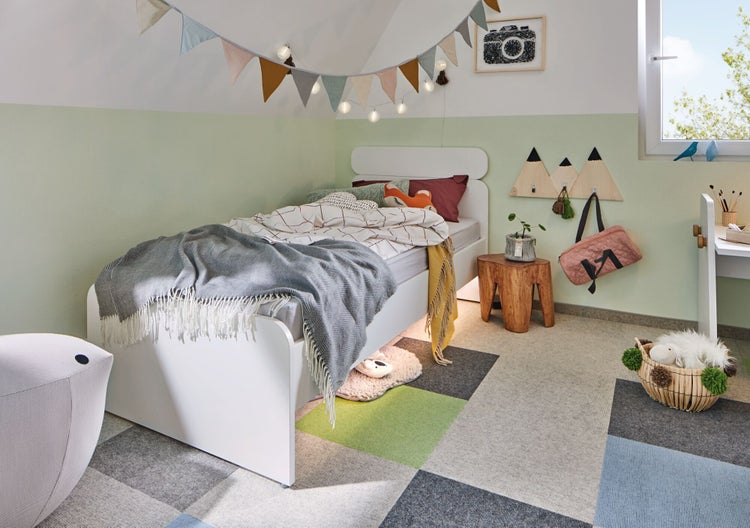Kinderzimmer mit Bett, Teppichfliesen und dekorativen Elementen
