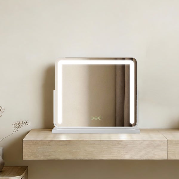 Quadratischer Kosmetikspiegel mit LED Beleuchtung auf einem Tisch.