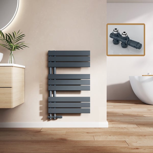 Grauer Badheizkörper an der Wand mit Thermostatventil