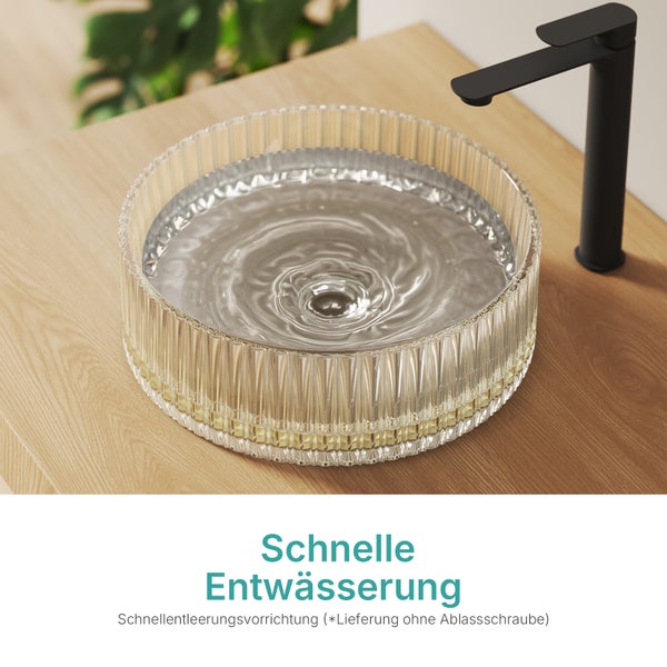 Auf einer Holzoberfläche steht ein Waschbecken aus Glas mit einem schwarzen Wasserhahn.