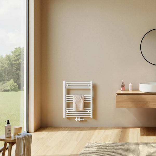 Moderner weißer Handtuchheizkörper in einem hellen Badezimmer mit Holzwaschtisch und großem Fenster mit Blick in den Garten.