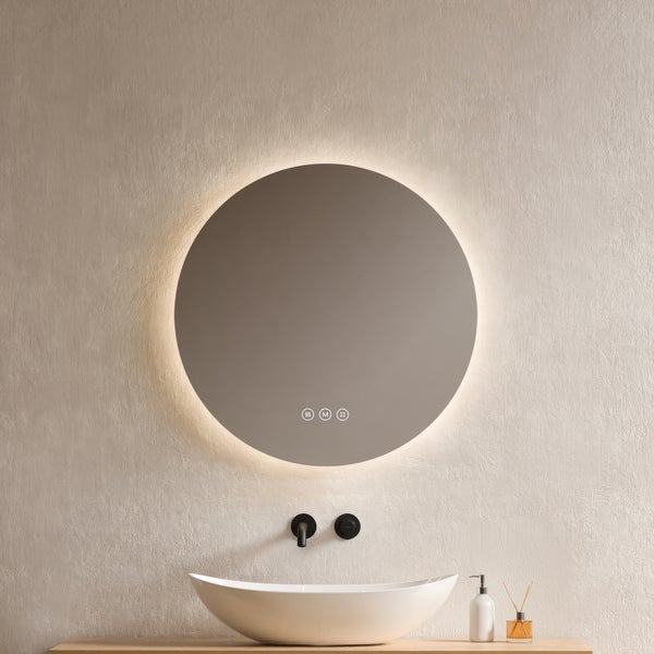 Runder Badezimmerspiegel mit LED-Hintergrundbeleuchtung und Touch-Sensoren über einem weißen Aufsatzwaschbecken und einer schwarzen Wandarmatur.