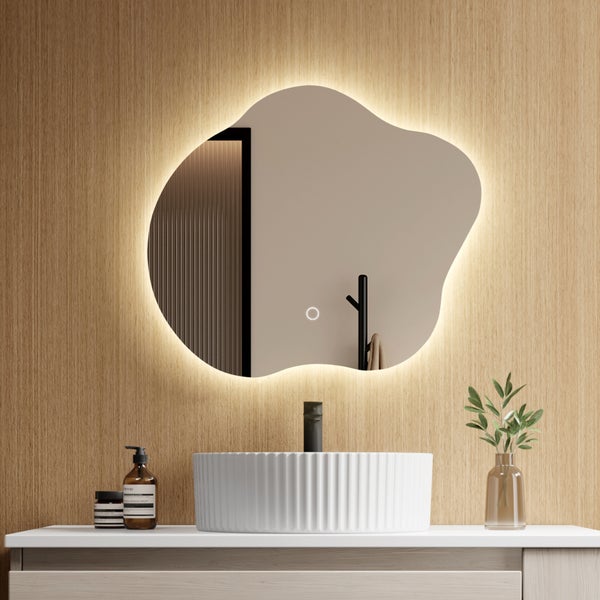 Organisch geformter LED-Badezimmerspiegel mit Hintergrundbeleuchtung und Touch-Sensor an Holzwand über weißem Aufsatzwaschbecken.