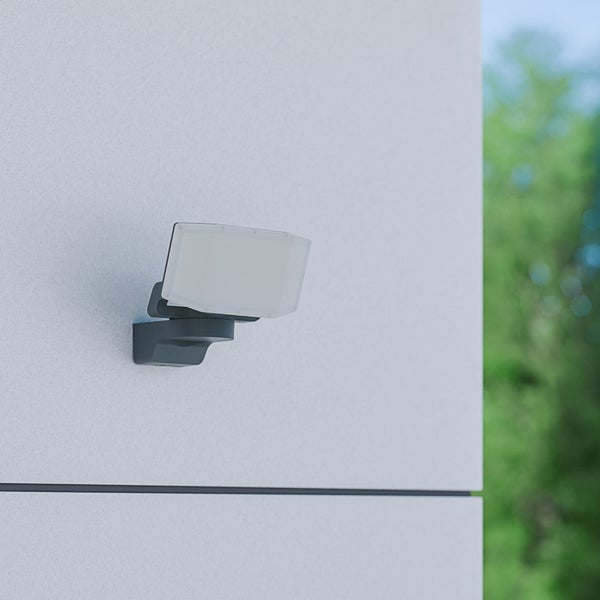 LED-Außenstrahler in Anthrazit mit flachem Gehäuse, an einer Fassade montiert.