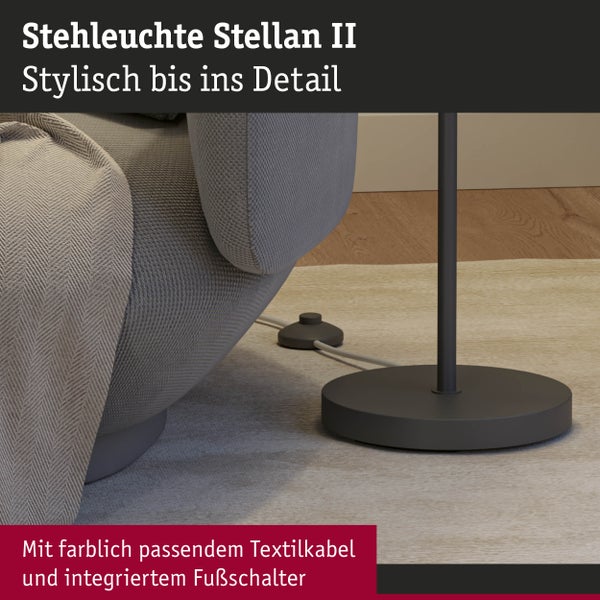 Stehlampe mit Fußschalter und Textilkabel neben Sessel auf Teppich