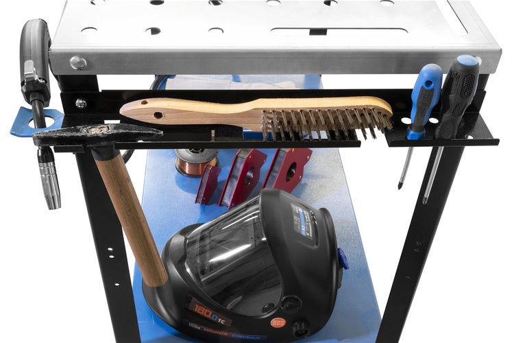 Werkbank mit Schweißhelm, Hammer, Drahtbürste und Schraubendrehern