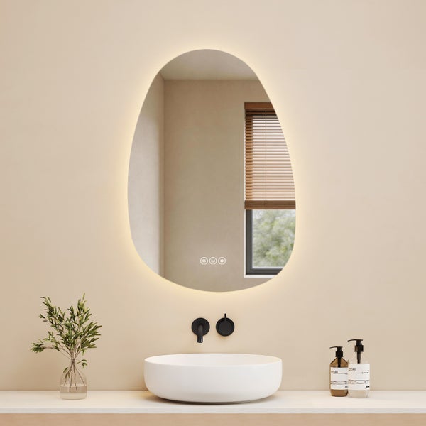 Modernes Badezimmer mit organisch geformtem LED-Spiegel, weißem Aufsatzwaschbecken und schwarzer Wandarmatur.