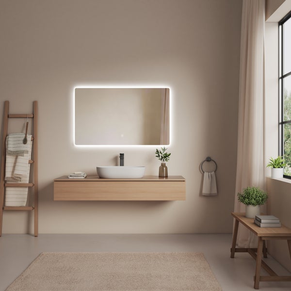 Helles Badezimmer mit Waschtischunterschrank, beleuchtetem Spiegel und dekorativen Elementen wie Handtuchleiter und Pflanzen