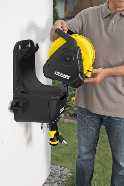 Person montiert Kärcher Schlauchbox an einer Wand