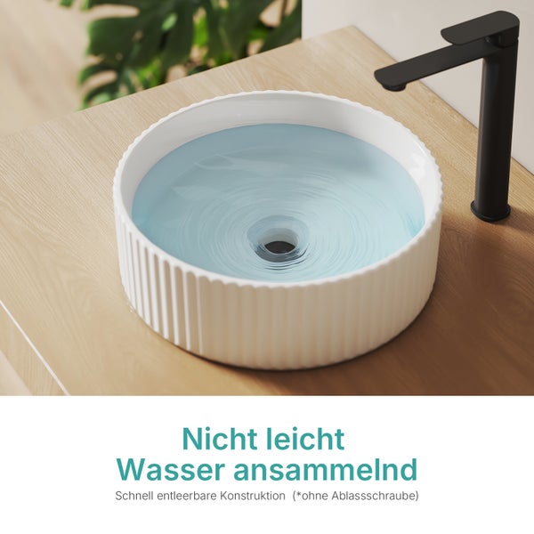 Aufsatzwaschbecken mit Wasser und schwarzer Armatur auf einer Holzoberfläche