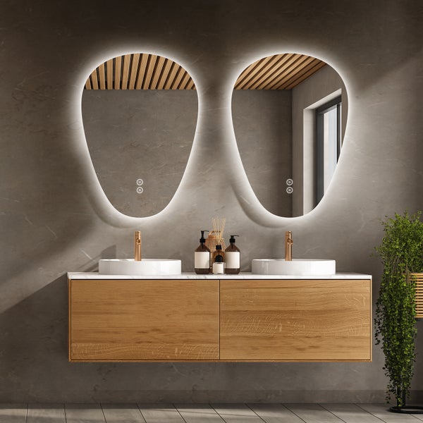 Modernes Doppelwaschbecken mit zwei organisch geformten LED Spiegeln und einem hängenden Waschtischunterschrank aus Holz in einem Badezimmer.