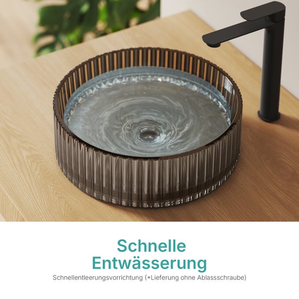 Rundes Aufsatzwaschbecken aus Glas mit Wasserhahn auf einer Holzplatte