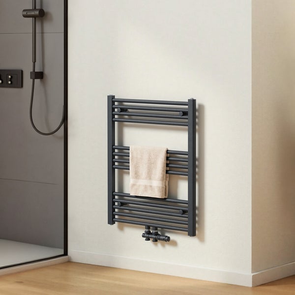 Grauer Handtuchwärmer mit einem Handtuch im Badezimmer.