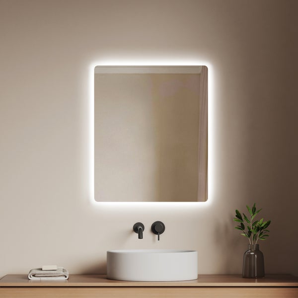 Badezimmer mit beleuchtetem Spiegel, Waschbecken und Armatur