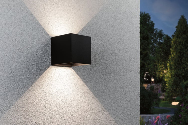 Quadratische Außenwandleuchte an einer Fassade mit Lichtstrahlen